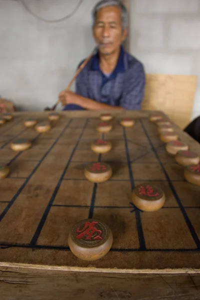 Few men are playing Chinese chess, named also XiangQ