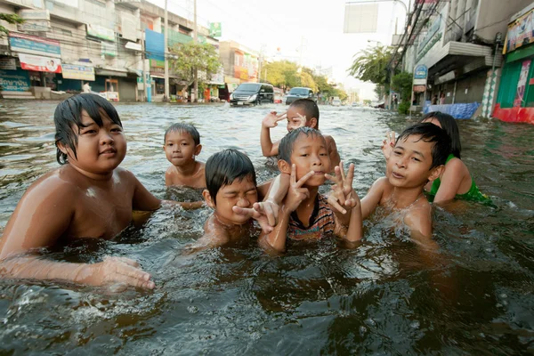 Children enjoy flooded streets to bathe with big health risks.