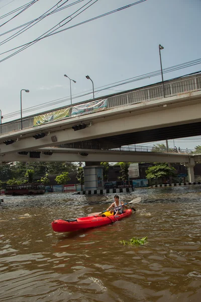 Bangkok, Thailand 2011, during the big floods that affected several provinces. Moving becomes difficult, people use small boats and canoes to move around.