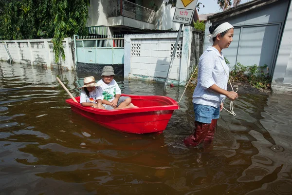 Bangkok, Thailand 2011, during the big floods that affected several provinces. Moving becomes difficult, people use small boats and canoes to move around.