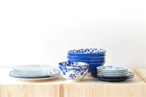 Blue and white dishes, plate and bowl on the cupboard at home.