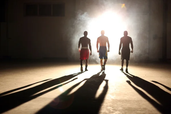 Three young men boxing workout in an old building