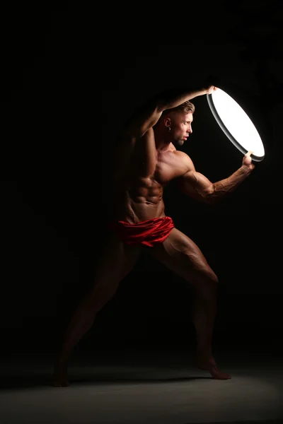 Young naked man, sexy strong muscular body with studio lighting