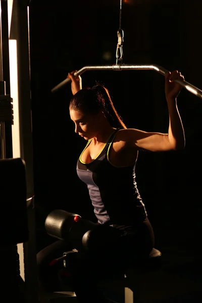 Fitness Woman holding simulator for swing press expressed muscles arms
