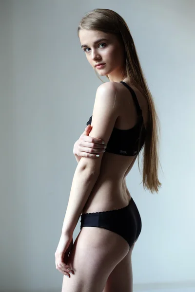 Standing model in bikini posing. White background