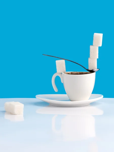 Cup with coffee, sugar and spoon.