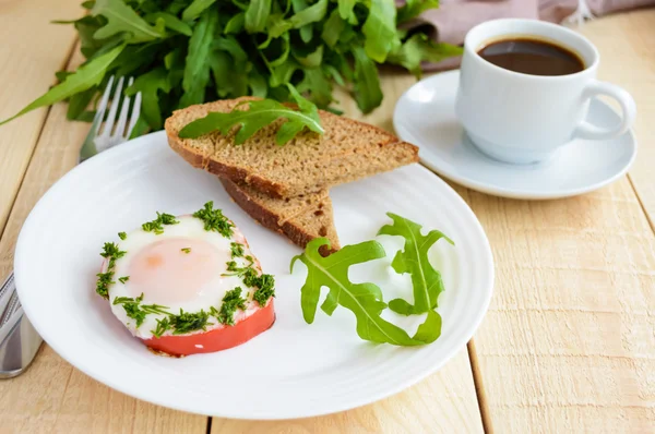 Scrambled eggs, baked in a ring bell pepper, toast, arugula leaves and a cup of coffee.
