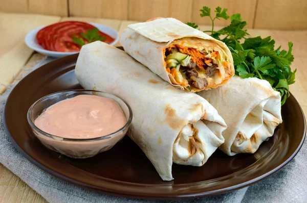 Shawarma - Middle East (Arabic) dish of pita (lavash) stuffed with: grilled meat, sauce, vegetables.