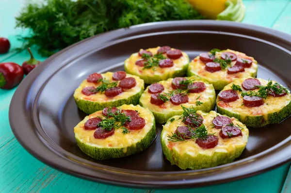 Small zucchini pizza on the circles with pepperoni and mozzarella. Close up