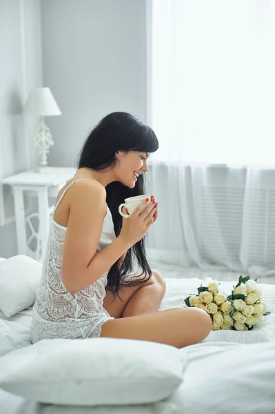 Young woman drinking coffee in bed