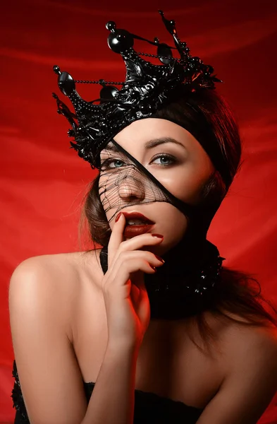 Girl in black crown and black veil on red background