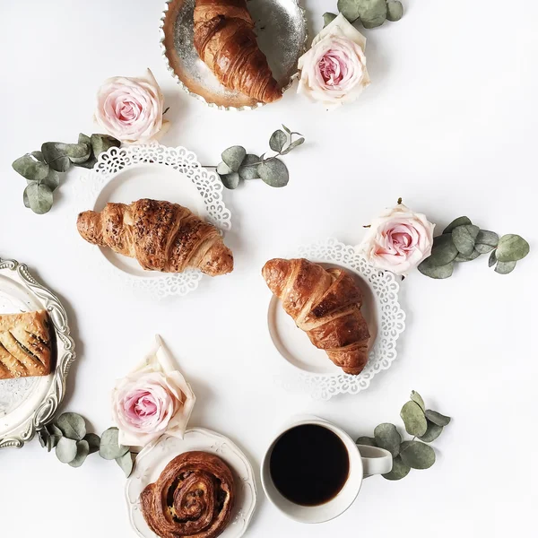Breakfast with croissants, pink rose flower