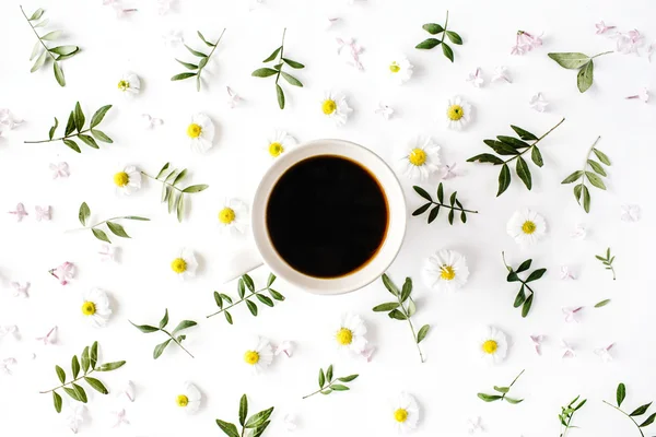Cup of coffee with chamomile flowers