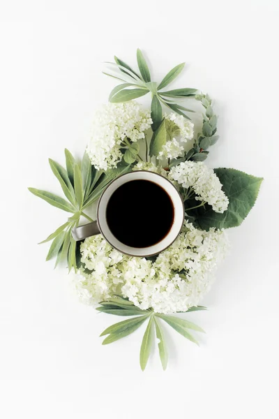 Coffee mug and white hydrangea flowers