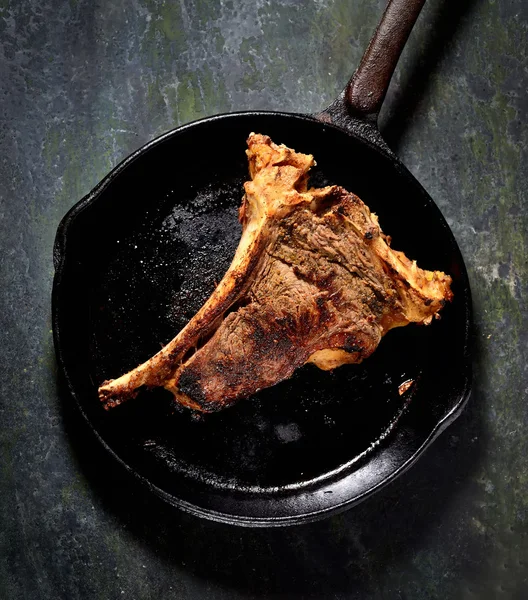 Fried steak in frying pan