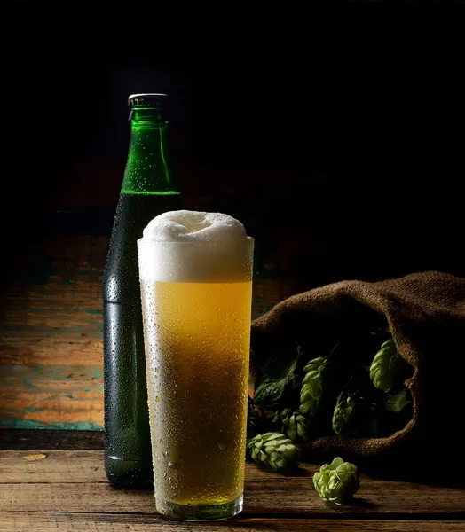 Beer glass with bottle and hops
