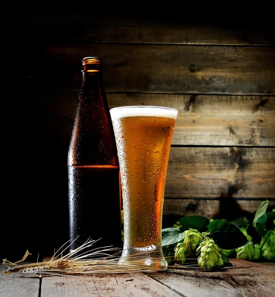 Beer glass with bottle and hops