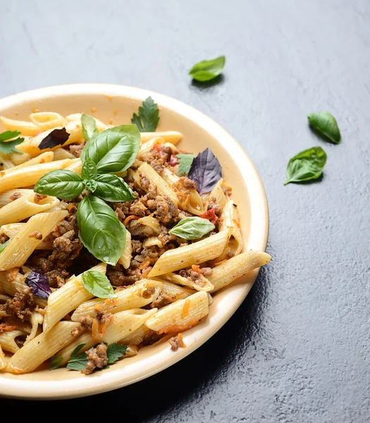 Pasta with meat and basil on a plate