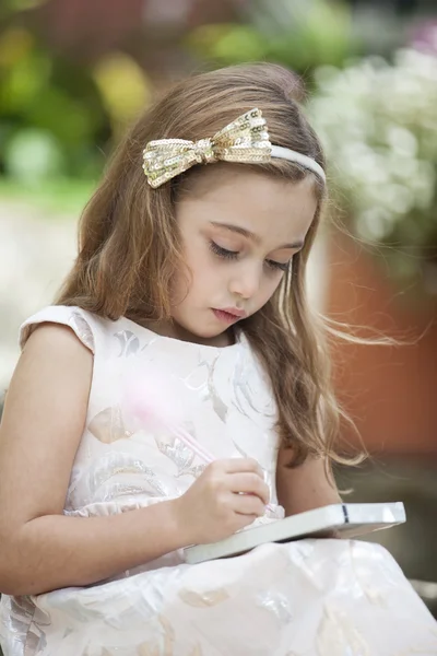 Little writer with her notebook and pencil