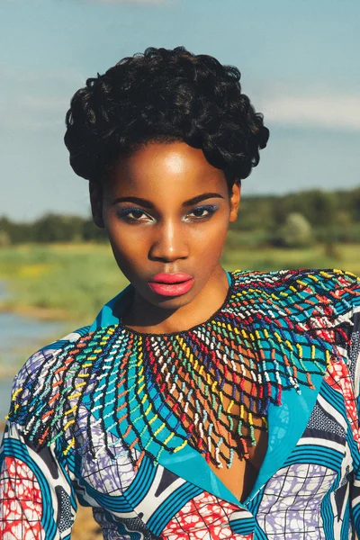 Beautiful black girl model in a blue dress and jewelry