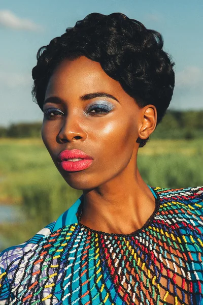 Beautiful black girl model in a blue dress and jewelry