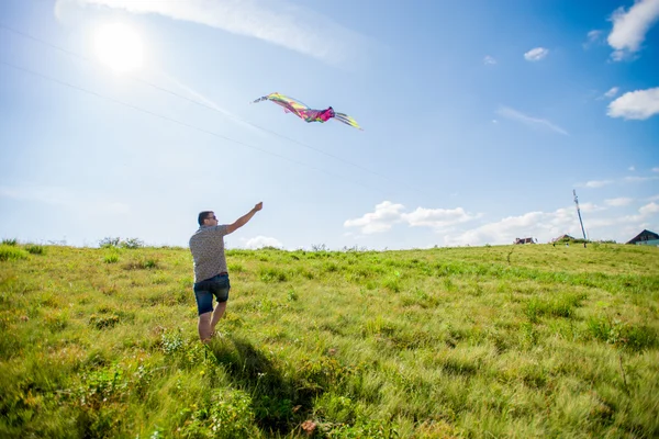 A man runs and launches a kite
