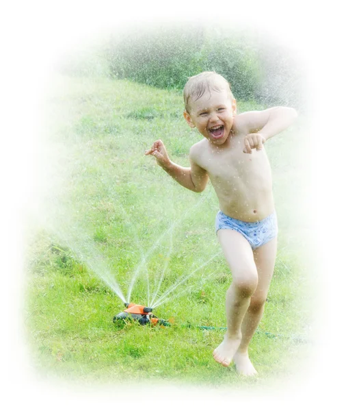Happy little boy having fun with water sprayer in the garden