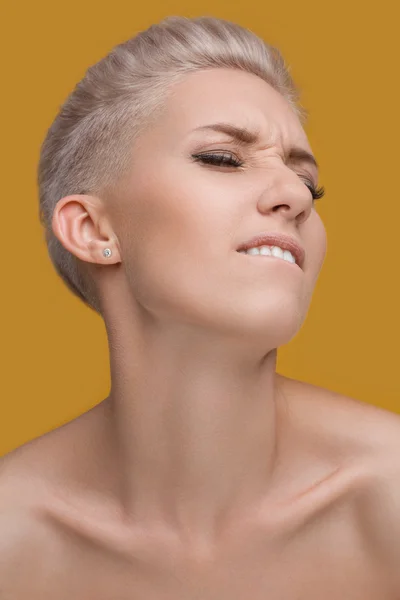 Emotional portrait of amazed woman on a yellow background