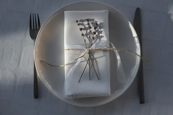 Table setting with napkins, plate, knife, fork and flower