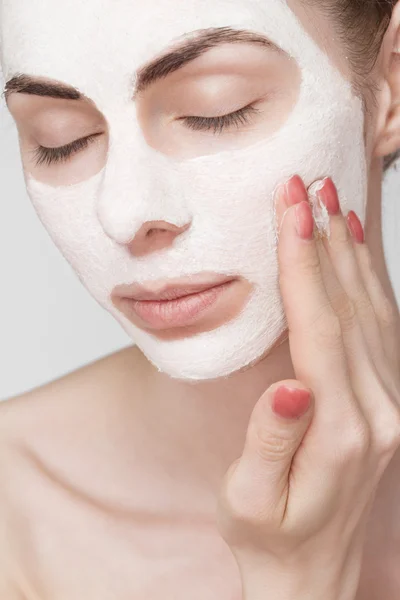 Spa girl applying facial mask