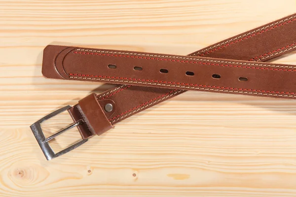 Leather stylish men\'s belt on the table.