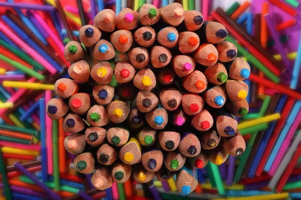 Colored pencils on background of bright markers. Selective focus