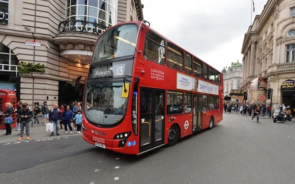 A red London bus drives on Shaftesbury Avenue to Piccadilly Circus