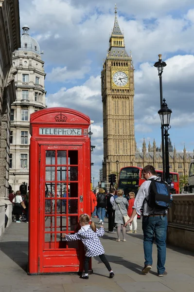 Tourists view a traditional red British phone box at Westminster
