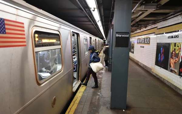 Rail passengers board a subway train at station