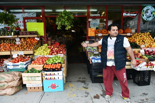 A man sell fruit at a supermarket store in Queens