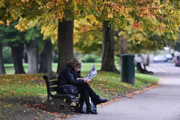 Tourists sit on a bench in Victoria Park