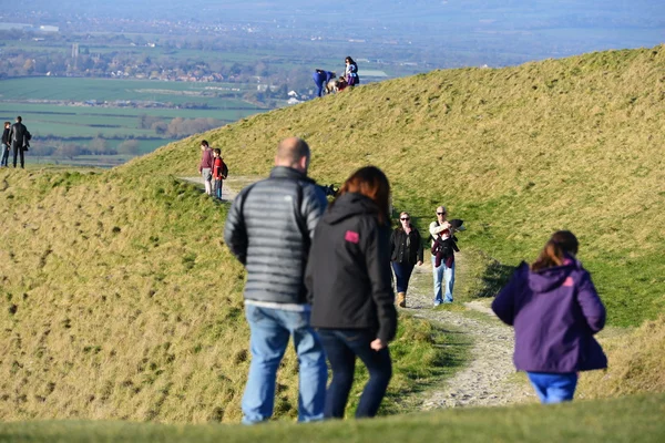 People enjoy a sunny day on the Westbury White Horse on the Salisbury Plain