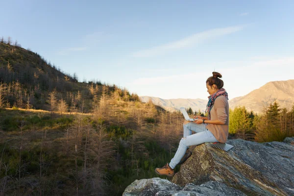 Woman with laptop on the mountain