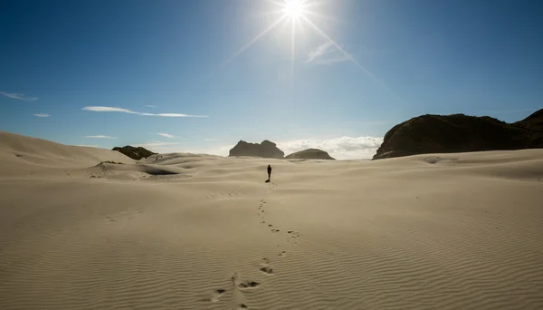 Woman traveler walking on sand dune