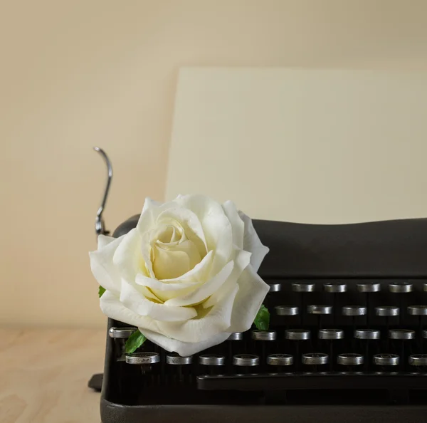 Image of vintage typewriter with white rose