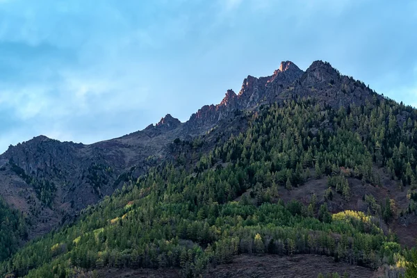 Mountain peak, illuminated by last rays of setting sun