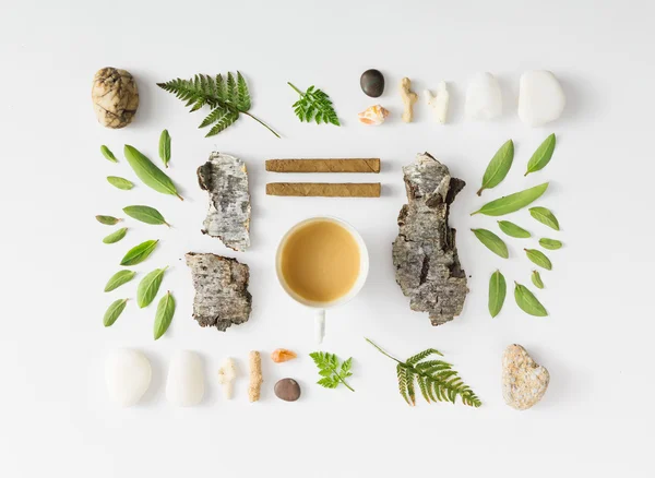 Creative natural layout made of leaves, stones, and tree bark.