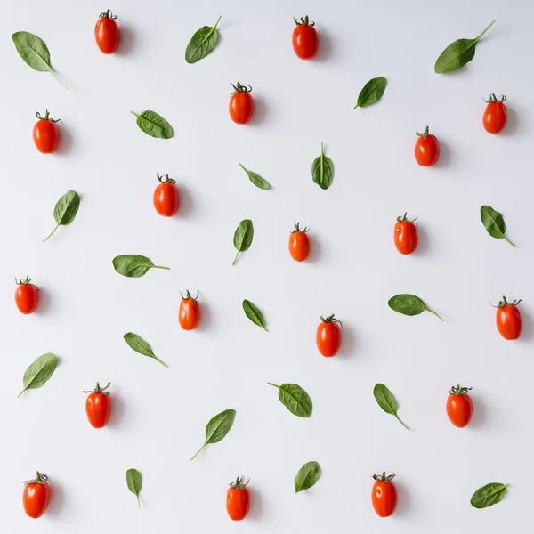 Cherry tomatoes and basil leaves pattern.