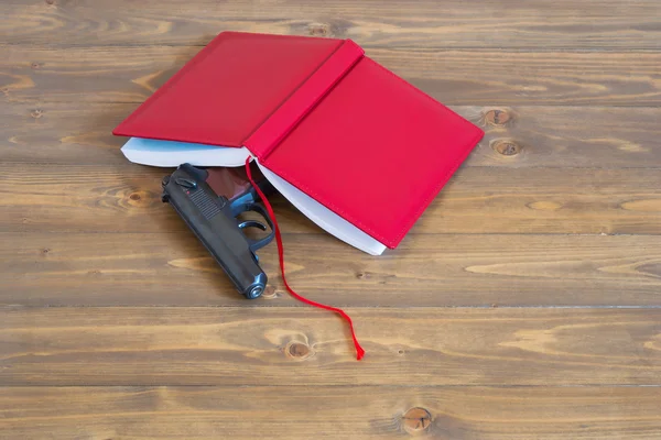 Diary in red hide a gun on the table