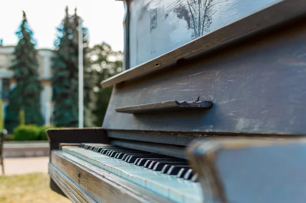 Old piano painted in blue color on the street