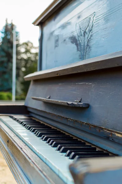 Old piano painted in blue color on the street