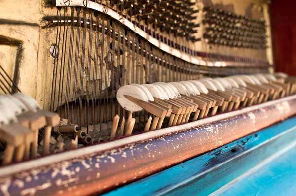 Old piano painted in blue color on the street