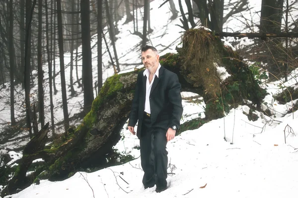 A bearded man in the costume winter snow woods