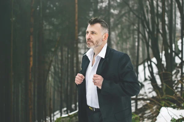 A bearded man in the costume winter snow woods